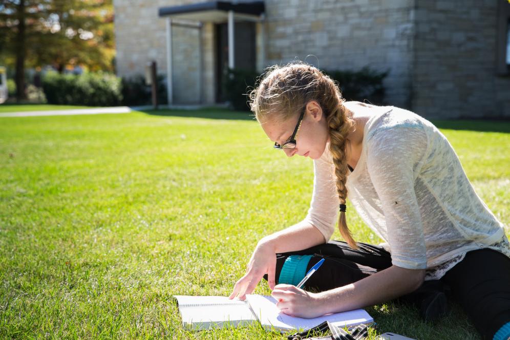 一个学生在外面学习. Being an office writer is one of many student employment opportunities...